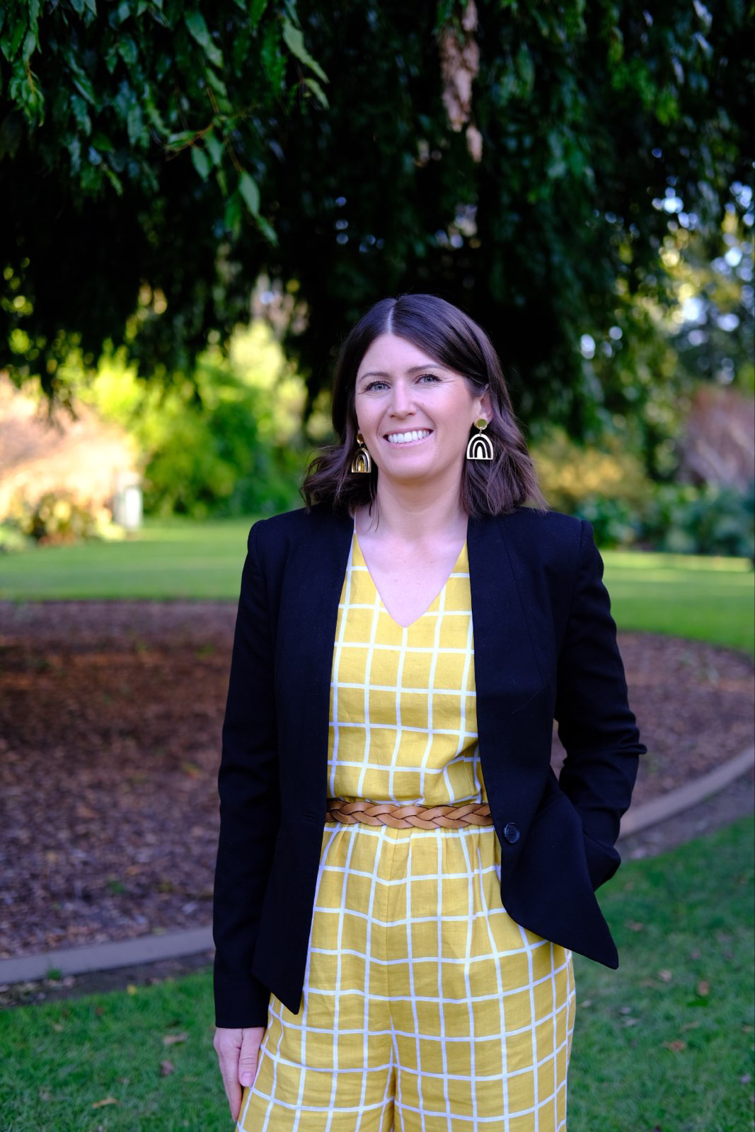 Candidate photo for Ashley Edwards Ashley Edwards, Albury City Councillor, Standing in a park with a yellow outfit.